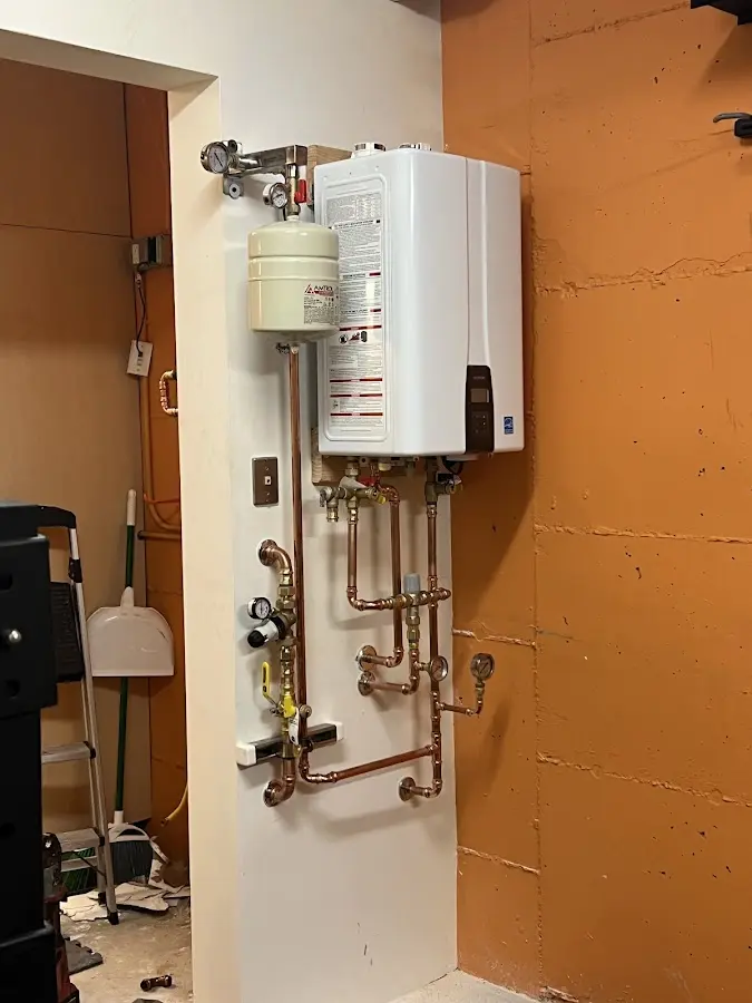 Plumbing technician inspecting water heater connections in Emerald Isle